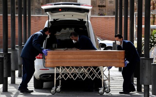 Des employés des pompes funèbres portant des masques transportent un cercueil vers le crématorium du cimetière de La Almudena à Madrid le 24 mars 2020 lors de l'enterrement d'une victime du coronavirus COVID-19. (Photo by OSCAR DEL POZO / AFP) Des employés des pompes funèbres portant des masques transportent un cercueil vers le crématorium du cimetière de La Almudena à Madrid le 24 mars 2020 lors de l'enterrement d'une victime du coronavirus COVID-19. (Photo by OSCAR DEL POZO / AFP)