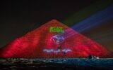 Spectacle lumineux sur la pyramide de Guizeh appelant le monde à se confiner, en pleine pandémie de coronavirus, le 30 mars 2020. (Crédit : Khaled DESOUKI / AFP)