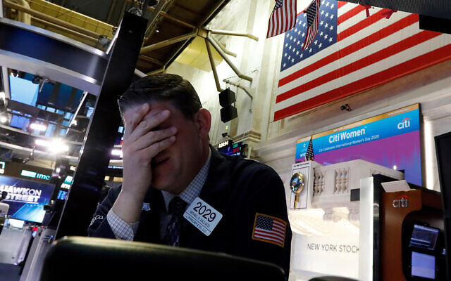 Un trader de Wall Street réagit à la chute des cours des actions à la Bourse de New York, le 9 mars 2020. (Crédit : AP / Richard Drew) Un trader de Wall Street réagit à la chute des cours des actions à la Bourse de New York, le 9 mars 2020. (Crédit : AP / Richard Drew)