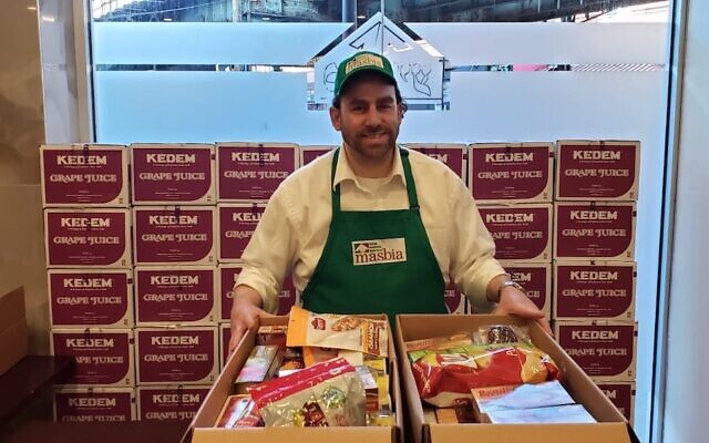 M. Pesach Gittleson, surveillant à Masbia kosher, prépare des cartons contenant de la nourriture pour les personnes qui pourraient être mises en quarantaine ou incapables de se procurer de la nourriture en raison de l'épidémie de coronavirus. (Alexander Rapaport via JTA)
