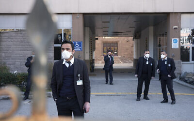 Des officiels de la sécurité sont à l'entrée de l'hôpital Zekai Tahir Burak où 17 passagers d'un vol de Turkish Airlines en provenance de Téhéran, suspectés d'être contaminés au coronavirus, ont été placés en quarantaine, à Ankara en Turquie, le mardi 25 février 2020.  (AP Photo / Burhan Ozbilici)