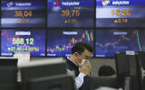 Un trader portant un masque au siège de la KEB Hana Bank à Séoul, en Corée du Sud, le 12 mars 2020. (Crédit : AP Photo/Ahn Young-joon)