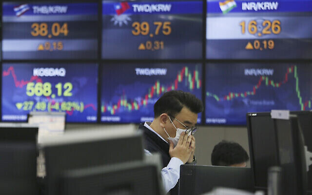 Un trader portant un masque au siège de la KEB Hana Bank à Séoul, en Corée du Sud, le 12 mars 2020. (Crédit : AP Photo/Ahn Young-joon)