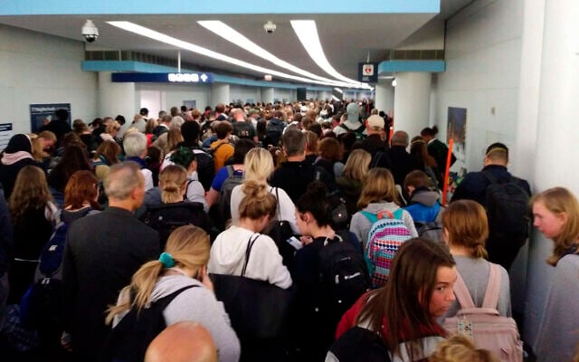 Des voyageurs font la queue pour passer la douane à l'aéroport international O'Hare de Chicago, le samedi 15 mars 2020. (Crédit : AP Photo/Michael Sadler) Des voyageurs font la queue pour passer la douane à l'aéroport international O'Hare de Chicago, le samedi 15 mars 2020. (Crédit : AP Photo/Michael Sadler)