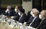 Sur cette photo publiée par le site internet officiel du Bureau de la présidence iranienne, des membres du cabinet portant des masques et des gants participent à une réunion à Téhéran, en Iran, le mercredi 18 mars 2020. (Bureau de la présidence iranienne via AP)