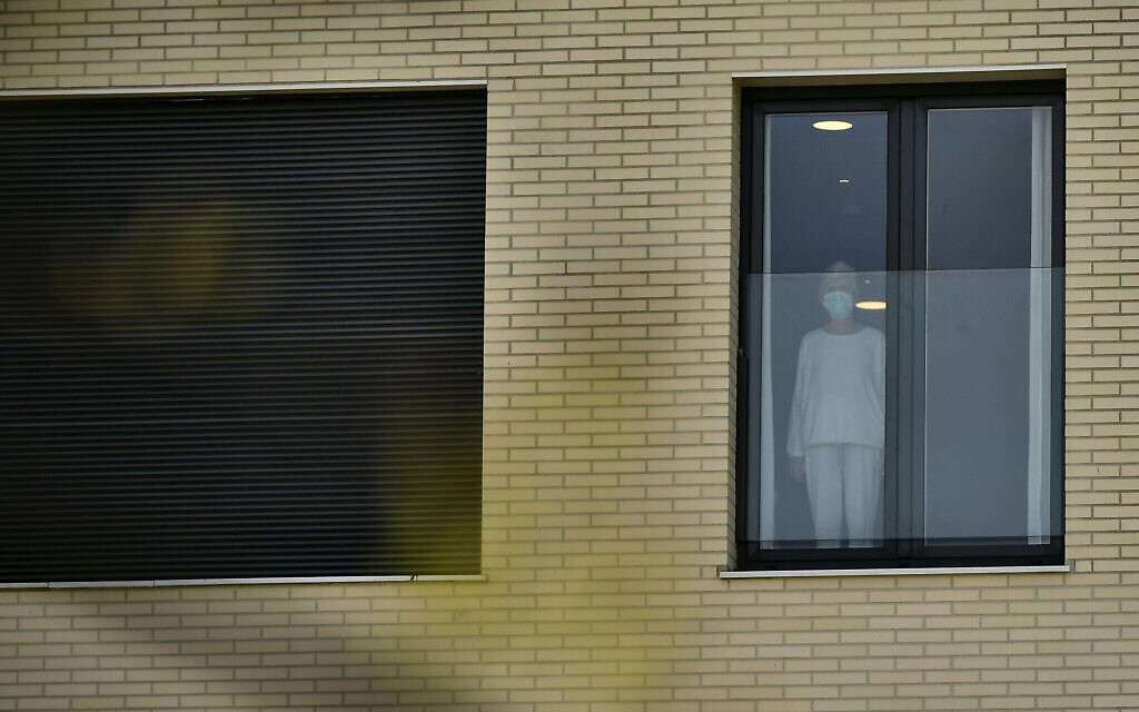 Une gemme portant un masque de protection à la fenêtre de la maison de retraite de San Martin où plusieurs personnes âgées sont touchées par le coronavirus à Vitoria, dans le nord de l'Espagne, le 19 mars 2020 (Crédit : AP Photo/Alvaro Barrientos) Une gemme portant un masque de protection à la fenêtre de la maison de retraite de San Martin où plusieurs personnes âgées sont touchées par le coronavirus à Vitoria, dans le nord de l'Espagne, le 19 mars 2020 (Crédit : AP Photo/Alvaro Barrientos)