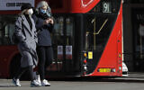 Deux femmes portent des masques de protection en pleine pandémie de coronavirus, à Londres, le 22 mars 2020. (Crédit : AP Photo/Kirsty Wigglesworth)