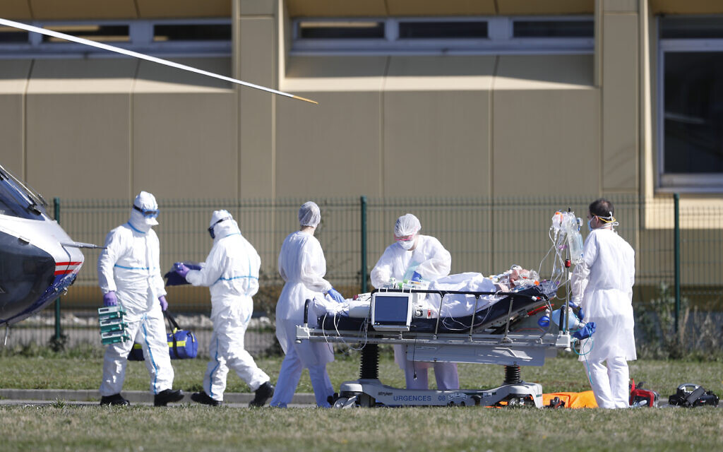Une victime de la COVID-19 est évacuée de l'hôpital civil de Mulhouse, dans l'est de la France, le lundi 23 mars 2020. (Crédit : AP Photo/Jean-Francois Badias)