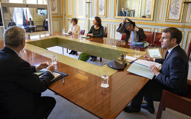Le président français Emmanuel Macron, en vidéoconférence avec les représentants des cultes, au palais de l'Elysée, le 23 mars 2020. (Crédit :Ian Langsdon, Pool via AP) Le président français Emmanuel Macron, en vidéoconférence avec les représentants des cultes, au palais de l'Elysée, le 23 mars 2020. (Crédit :Ian Langsdon, Pool via AP)