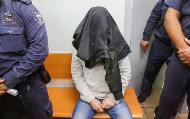 Alexander Leibman, un chauffeur de bus impliqué dans un accident mortel sur l'autoroute 40 près de l'aéroport Ben Gurion, est escorté par un gardien de prison au tribunal de Rishon Lezion le 23 décembre 2019. (Crédit : Flash90) Alexander Leibman, un chauffeur de bus impliqué dans un accident mortel sur l'autoroute 40 près de l'aéroport Ben Gurion, est escorté par un gardien de prison au tribunal de Rishon Lezion le 23 décembre 2019. (Crédit : Flash90)