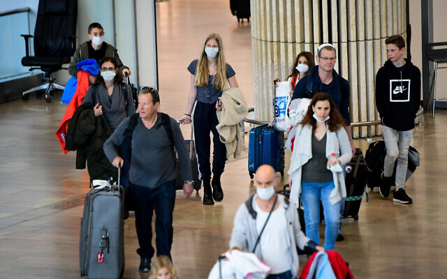 Des personnes portant des masques de protection par crainte du coronavirus arrivent à l'aéroport international Ben Gurion, le 10 mars 2020. (Avshalom Sassoni/Flash90) Des personnes portant des masques de protection par crainte du coronavirus arrivent à l'aéroport international Ben Gurion, le 10 mars 2020. (Avshalom Sassoni/Flash90)