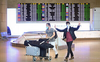 Des personnes portant un masque facial arrivent à l'aéroport international Ben Gurion, le 11 mars 2020. (Flash90)