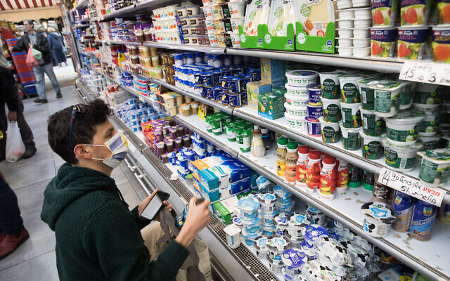 Un homme porte un masque pour se protéger du coronavirus en faisant des courses dans un supermarché de Jérusalem le 15 mars 2020. (Crédit : Nati Shohat/Flash90)