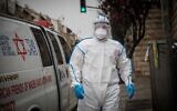 Un secouriste du Magen David Adom portant une tenue de protection contre le coronavirus arrive pour tester un patient présentant des symptômes de Covid-19, à Jérusalem, le 16 mars 2020. (Crédit : Yonatan Sindel/Flash90)