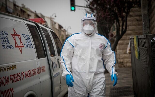 Un secouriste du Magen David Adom portant une tenue de protection contre le coronavirus arrive pour tester un patient présentant des symptômes de Covid-19, à Jérusalem, le 16 mars 2020. (Crédit : Yonatan Sindel/Flash90)