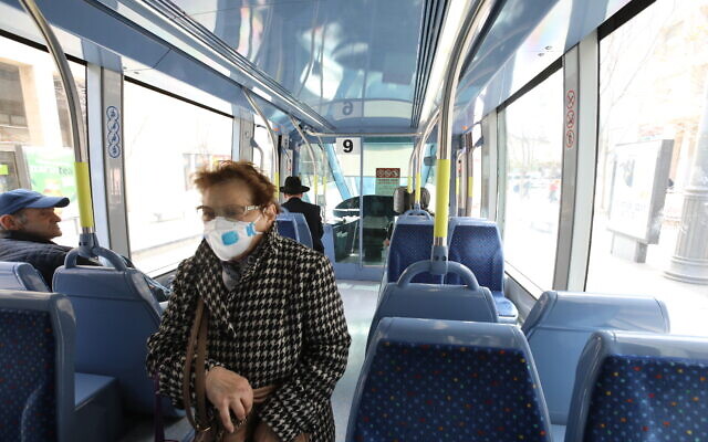Des Israéliens munis de masques de protection, dans un bus à Jérusalem, le 17 mars 2020. (Crédit :Yossi Zamir/Flash90)