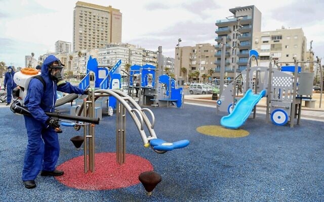 Opération de désinfection d'un terrain de jeu public à Bat Yam dans le cadre des mesures visant à prévenir la propagation du coronavirus, le 18 mars 2020. (Crédit : Tomer Neuberg/Flash90)