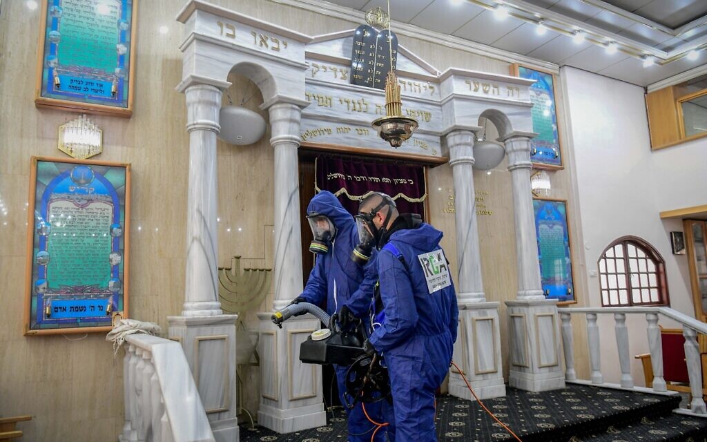 Des agents portant des vêtements de protection désinfectent une synagogue à Bat Yam, le 18 mars 2020, dans le cadre des mesures visant à prévenir la propagation du coronavirus. (Flash90) Des agents portant des vêtements de protection désinfectent une synagogue à Bat Yam, le 18 mars 2020, dans le cadre des mesures visant à prévenir la propagation du coronavirus. (Flash90)