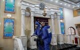 Des agents portant des vêtements de protection désinfectent une synagogue à Bat Yam, le 18 mars 2020, dans le cadre des mesures visant à prévenir la propagation du coronavirus. (Flash90)