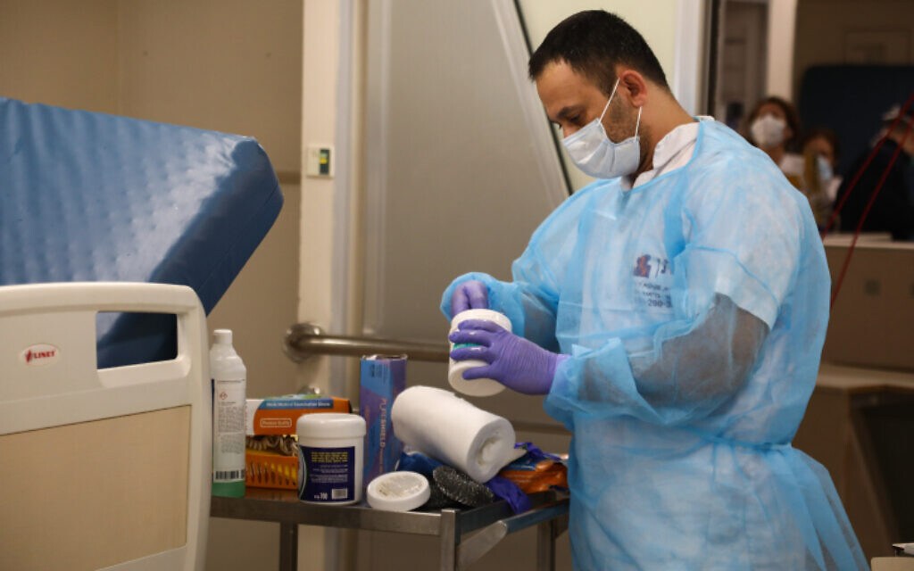 Un employé prépare des médicaments à l'hôpital Ichilov de Tel Aviv pour des personnes infectées par le coronavirus, le 19 mars 2020. (Crédit : Flash90) Un employé prépare des médicaments à l'hôpital Ichilov de Tel Aviv pour des personnes infectées par le coronavirus, le 19 mars 2020. (Crédit : Flash90)