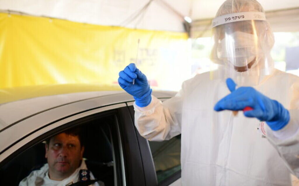 Un membre du Magen David Adom porte une tenue de protection dans un poste de dépistage du Covid-19 à Tel-Aviv, le 20 mars 2020. (Crédit : Tomer Neuberg/Flash90)