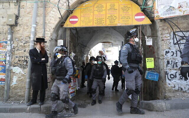 Des policiers dans le quartier juif ultra-orthodoxe de Mea Shearim à Jérusalem ferment des magasins et dispersent des rassemblements publics sur ordre du gouvernement afin de contenir la propagation du coronavirus, le 24 mars 2020. (Yonatan Sindel/Flash90)