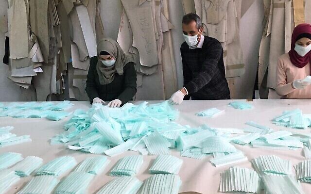 Les employés d'une usine de Hébron fabriquent des masques pour le marché palestinien (Autorisation : Amjad Zughayir) Les employés d'une usine de Hébron fabriquent des masques pour le marché palestinien (Autorisation : Amjad Zughayir)