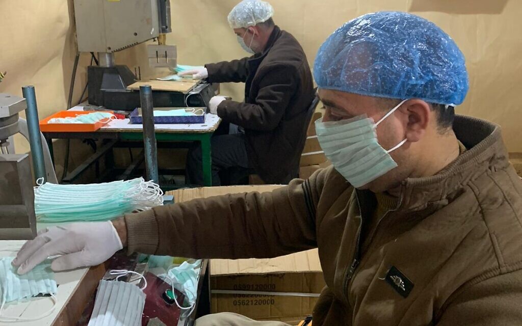 Les employés d'une usine de Hébron fabriquent des masques pour le marché palestinien en Cisjordanie (Autorisation : Amjad Zughayir) Les employés d'une usine de Hébron fabriquent des masques pour le marché palestinien en Cisjordanie (Autorisation : Amjad Zughayir)