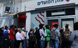 Des Israéliens font la queue devant une banque près du marché Hatikva, Tel Aviv, le 15 mars 2020. (Crédit : Tomer Neuberg/Flash90)