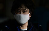 Une femme porte un masque de protection dans un contexte de crainte face à l'épidémie de coronavirus dans le hall d'arrivée de l'aéroport Ben-Gurion, près de Tel Aviv, le 30 janvier 2020 (Crédit : Tomer Neuberg/Flash90)