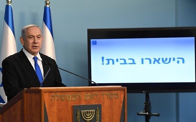 Le Premier ministre Benjamin Netanyahu en conférence de presse sur le coronavirus, le 17 mars 2020. "Restez chez vous !", enjoint le texte affiché sur l'écran. (Crédit : Kobi Gideon/GPO) Le Premier ministre Benjamin Netanyahu en conférence de presse sur le coronavirus, le 17 mars 2020. "Restez chez vous !", enjoint le texte affiché sur l'écran. (Crédit : Kobi Gideon/GPO)