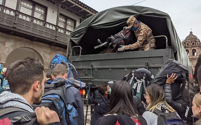 Un soldat péruvien décharge les sacs de voyageurs israéliens à l'aéroport de Cusco, le 19 mars 2020. (rédit : Amsalem Tours)