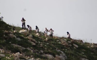 Photo d'illustration : Des résidents de Homesh jettent des pierres sur des Palestiniens, le 26 mars 2020. (Crédit : Yesh Din)