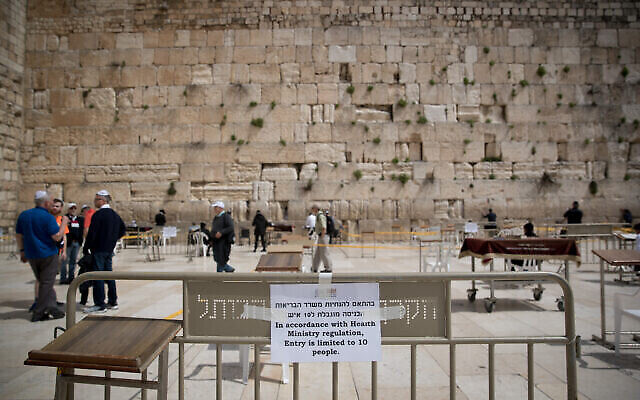 Illustration : les gens prient dans des espaces clos, ne permettant que 10 personnes à la fois, au Mur occidental, dans la Vieille Ville de Jérusalem, le 15 mars 2020. (Crédit : Yonatan Sindel / Flash90)