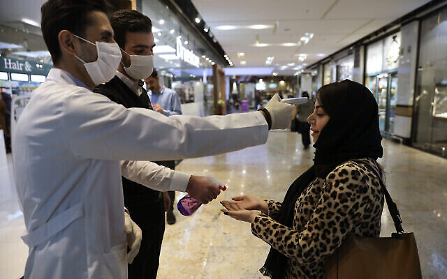 On contrôle la température d'une femme et on lui désinfecte les mains alors qu'elle entre dans le centre commercial Palladium, dans le nord de Téhéran, en Iran, le 3 mars 2020. (AP Photo/Vahid Salemi) On contrôle la température d'une femme et on lui désinfecte les mains alors qu'elle entre dans le centre commercial Palladium, dans le nord de Téhéran, en Iran, le 3 mars 2020. (AP Photo/Vahid Salemi)