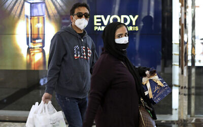 Des gens portent des masques et des gants au centre commercial Palladium dans le nord de Téhéran en Iran, le mardi 3 mars 2020. (AP Photo/Vahid Salemi)