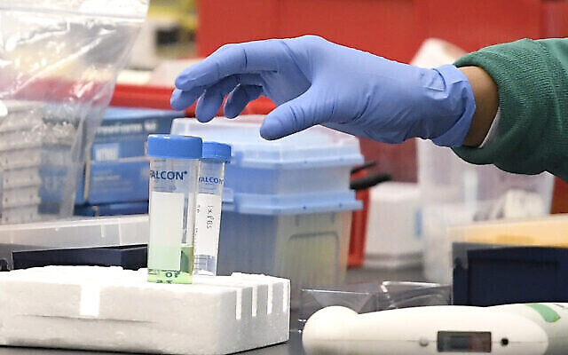 Un chercheur à Protein Sciences prend un tube dans un laboratoire, le jeudi 12 mars 2020 à Meriden, Connecticut. (AP Photo/Jessica Hill)