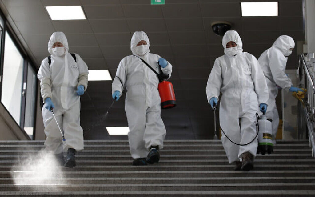 Des employés portant des masques de protection désinfectent par précaution contre le nouveau coronavirus dans une station du métro de Séoul, en Corée du Sud, le vendredi 13 mars 2020. (AP Photo/Lee Jin-man) Des employés portant des masques de protection désinfectent par précaution contre le nouveau coronavirus dans une station du métro de Séoul, en Corée du Sud, le vendredi 13 mars 2020. (AP Photo/Lee Jin-man)