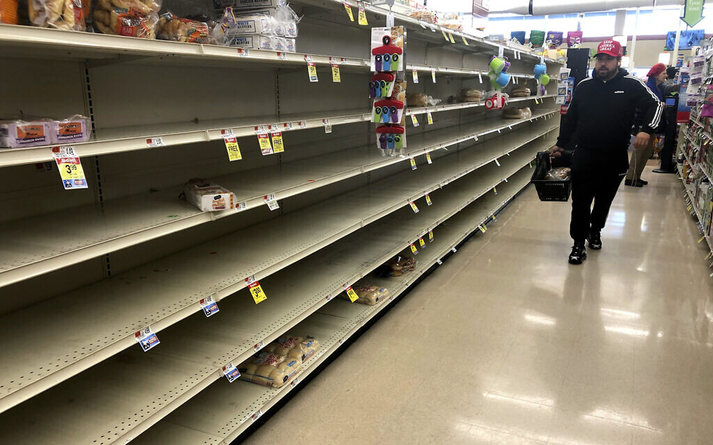 Un client passe devant les étagères vides où le pain est normalement proposé à la vente dans un supermarché, le dimanche 15 mars 2020 à Boston. (AP Photo/Steven Senne) Un client passe devant les étagères vides où le pain est normalement proposé à la vente dans un supermarché, le dimanche 15 mars 2020 à Boston. (AP Photo/Steven Senne)