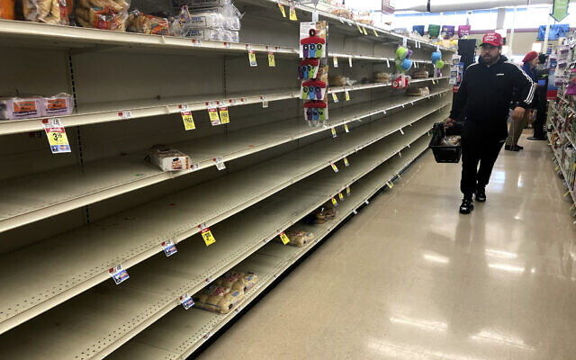 Un client passe devant les étagères vides où le pain est normalement proposé à la vente dans un supermarché, le dimanche 15 mars 2020 à Boston. (AP Photo/Steven Senne) Un client passe devant les étagères vides où le pain est normalement proposé à la vente dans un supermarché, le dimanche 15 mars 2020 à Boston. (AP Photo/Steven Senne)