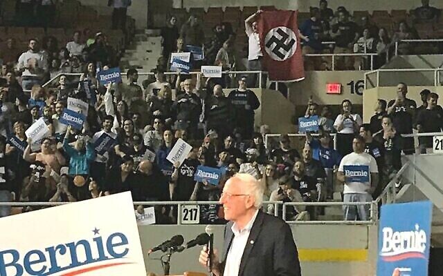 Un homme déroule un drapeau nazi lors d'un meeting de Bernie Sanders dans l'Arizona le 5 mars 2020. (Capture écran/YouTube) Un homme déroule un drapeau nazi lors d'un meeting de Bernie Sanders dans l'Arizona le 5 mars 2020. (Capture écran/YouTube)