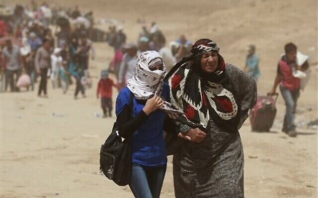 Sur cette photo du 20 août 2013, des réfugiés syriens traversent la frontière irakienne au point de passage de Peshkhabour à Dahouk, à 430 kilomètres au nord-ouest de Bagdad, en Irak. Les scientifiques de haut niveau affirment que le changement climatique va compliquer et aggraver les problèmes de sécurité mondiale existants, tels que les guerres civiles, les conflits entre les nations et les réfugiés. (AP Photo/Hadi Mizban, File) Sur cette photo du 20 août 2013, des réfugiés syriens traversent la frontière irakienne au point de passage de Peshkhabour à Dahouk, à 430 kilomètres au nord-ouest de Bagdad, en Irak. Les scientifiques de haut niveau affirment que le changement climatique va compliquer et aggraver les problèmes de sécurité mondiale existants, tels que les guerres civiles, les conflits entre les nations et les réfugiés. (AP Photo/Hadi Mizban, File)