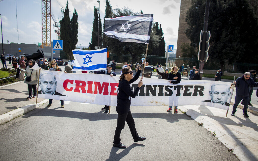 Des citoyens agitent des drapeaux israéliens, lors d'une manifestation devant le Parlement israélien à Jérusalem, le jeudi 19 mars 2020, accusant le gouvernement du Premier ministre Benjamin Netanyahu d'exploiter la crise du coronavirus pour consolider son pouvoir et saper les fondements démocratiques d'Israël. (Crédit : AP / Eyal Warshavsky) Des citoyens agitent des drapeaux israéliens, lors d'une manifestation devant le Parlement israélien à Jérusalem, le jeudi 19 mars 2020, accusant le gouvernement du Premier ministre Benjamin Netanyahu d'exploiter la crise du coronavirus pour consolider son pouvoir et saper les fondements démocratiques d'Israël. (Crédit : AP / Eyal Warshavsky)