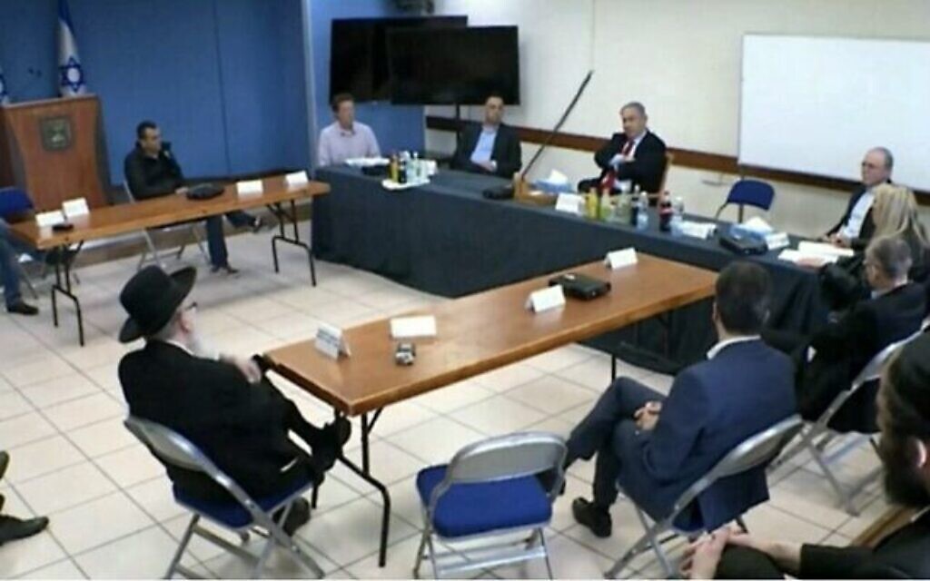 Le Premier ministre Benjamin Netanyahu tient une réunion pour décider des mesures à prendre pour contenir le coranavirus. Les participants sont assis à distance les uns des autres, le 13 mars 2020. Le Prof. Avi Simhon est le deuxième en partant de la droite. (Capture d'écran/Douzième chaîne)