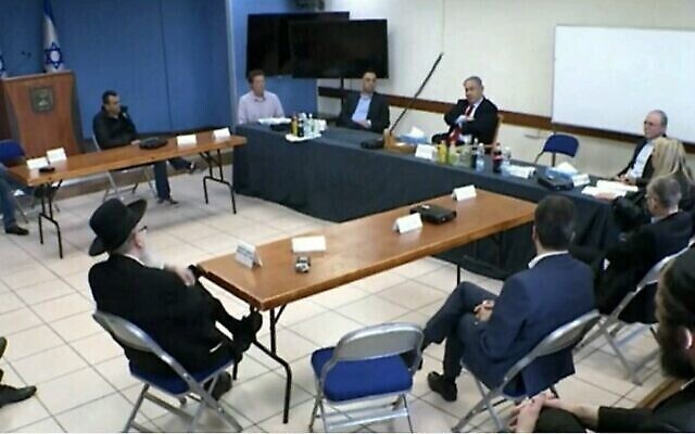 Le Premier ministre Benjamin Netanyahu tient une réunion pour décider des mesures à prendre pour contenir le coranavirus. Les participants sont assis à distance les uns des autres, le 13 mars 2020. Le Prof. Avi Simhon est le deuxième en partant de la droite. (Capture d'écran/Douzième chaîne)