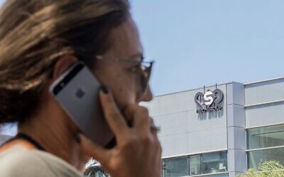 Une femme israélienne utilise son téléphone devant un bâtiment à Herzliya qui héberge la société de renseignement du groupe NSO, le 28 août 2016. (Jack Guez/AFP/Fichier)