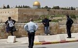 Des policiers israéliens ordonnent à des gens, aux abords de la Vieille Ville de Jérusalem, de rentrer chez eux dans le cadre des directives de lutte contre le coronavirus, le 27 mars 2020 (Crédit : Ahmad Gharabli/AFP)
