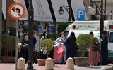 Des touristes portant des masques quittent l'hôtel Mena à Ryad le 30 mars 2020 après y avoir séjourné en quarantaine. (Photo par FAYEZ NURELDINE / AFP)
