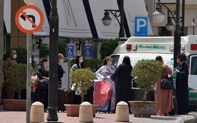 Des touristes portant des masques quittent l'hôtel Mena à Ryad le 30 mars 2020 après y avoir séjourné en quarantaine. (Photo par FAYEZ NURELDINE / AFP) Des touristes portant des masques quittent l'hôtel Mena à Ryad le 30 mars 2020 après y avoir séjourné en quarantaine. (Photo par FAYEZ NURELDINE / AFP)