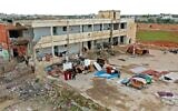Cette photo du 1er avril 2020 montre un bâtiment d'école fortement endommagé par d'anciens bombardements. Il est actuellement habité par des familles déplacées dans la ville de Binnish tenue par les rebelles dans la province d'Idleb du nord est de la Syrie. (Crédit : Omar HAJ KADOUR / AFP)